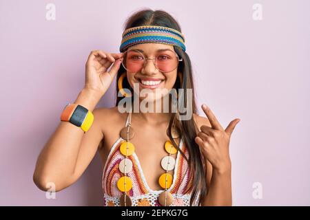 Belle femme hispanique portant le style bohème et hippie souriant heureux pointer avec la main et le doigt Banque D'Images