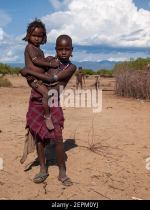 Young Girl holding arbore un autre enfant Banque D'Images