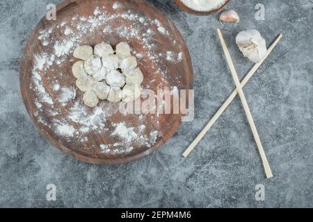 Boulettes crues sur plaque de bois avec baguettes Banque D'Images