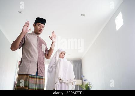 le mari et la femme musulmans d'asie prient la jamaah ensemble chez eux Banque D'Images