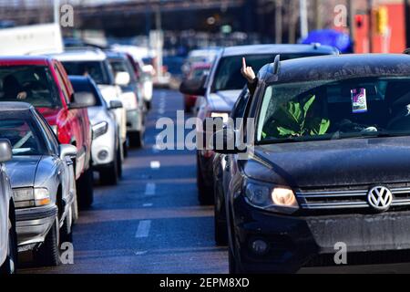 Calgary, Alberta, Canada. 27 février 2021. Un automobiliste fait des gestes à la manifestation anti-masque ''Freedom March'' à Calgary, Alb., le 27 février 2021. La marche a été menée par des gens qui ont porté des torches tiki dit pour signifier la lumière du seigneur, mais qui rappellent également le rassemblement de Charlottesville ''Unite the Right''' en 2017. Crédit : Gavin John/ZUMA Wire/Alay Live News Banque D'Images