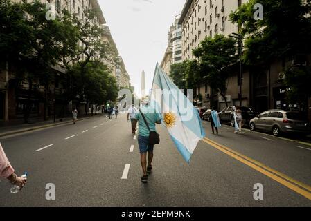 Buenos Aires, Argentine. 27 février 2021. Un manifestant portant un immense drapeau après la manifestation. Convoquée par Together for change, une foule de personnes a manifesté sur la Plaza de Mayo contre le gouvernement, le plan de vaccination et pour montrer leur colère contre le gouvernement. Crédit : SOPA Images Limited/Alamy Live News Banque D'Images