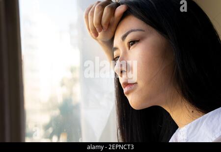 Vue de côté de la jeune femme de direction ethnique contre laquelle elle se penche dans l'espace de travail Banque D'Images