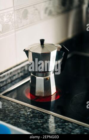 Cafetière avec plaque de cuisson en métal et poignée en plastique sur le moderne plaque chauffante dans la cuisine de la maison à la lumière du jour Banque D'Images