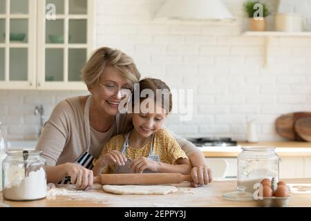 Boulangerie de cuisine nounou à pâte roulante pour femmes plus âgées avec un petit enfant Banque D'Images