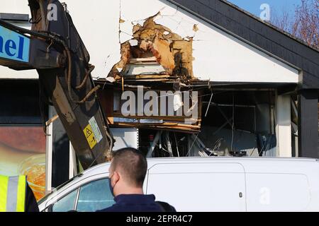 Dymchurch, Kent, Royaume-Uni. 28 février 2021. Les voleurs enhardis ont tenté un RAID audacieux sur ce Tesco express dans la rue Dymchurch Hugh après avoir conduit une excavatrice sur chenilles Volvo ECR235E dans les premières heures de la matinée, lors d'une tentative de vol en espèces. Un magasin a été laissé avec des "dommages importants" dans une tentative infructueuse de déchirer une machine à billets avec un creuseur, selon la police. Un coin du bâtiment se trouve en tatters. On croyait que le creuseur avait été volé à Dymchurch Beach. Crédit photo : Paul Lawrenson/Alay Live News Banque D'Images