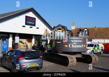 Dymchurch, Kent, Royaume-Uni. 28 février 2021. Les voleurs enhardis ont tenté un RAID audacieux sur ce Tesco express dans la rue Dymchurch Hugh après avoir conduit une excavatrice sur chenilles Volvo ECR235E dans les premières heures de la matinée, lors d'une tentative de vol en espèces. Un magasin a été laissé avec des "dommages importants" dans une tentative infructueuse de déchirer une machine à billets avec un creuseur, selon la police. Un coin du bâtiment se trouve en tatters. On croyait que le creuseur avait été volé à Dymchurch Beach. Crédit photo : Paul Lawrenson/Alay Live News Banque D'Images