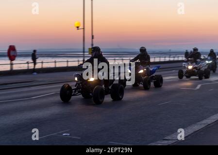 Groupe de motocyclistes en quad arrivant à Southend on Sea, Essex, Royaume-Uni, au crépuscule pendant le confinement de la COVID 19. Les cyclistes qui voyagent à vélo avec le ciel rouge du coucher du soleil en soirée Banque D'Images