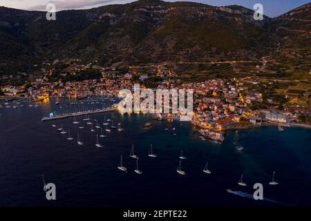 Un drone aérien a été abattu dans la nuit avec le port de la ville de Komiza Lumière de la ville sur l'île vis en Croatie, en été crépuscule Banque D'Images