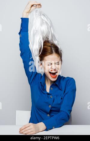 la femme prend la perruque blanche de la tête des émotions assis à tableau Banque D'Images