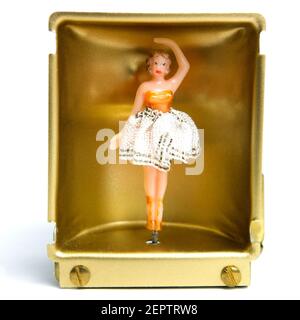 Une figurine de danseuse vintage dans une boîte d'affichage en or, mettant en valeur une pose gracieuse et un design de robe complexe Banque D'Images