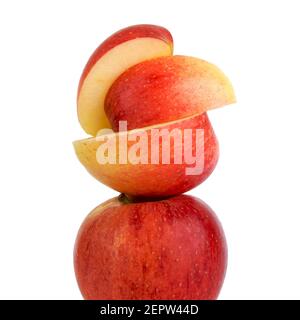 Pommes rouges empilées artistiquement avec un segment tranché reposant sur le dessus pour une présentation attrayante Banque D'Images