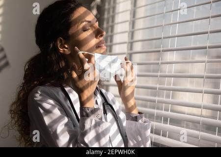 Gros plan femme fatiguée médecin prenant le masque médical Banque D'Images