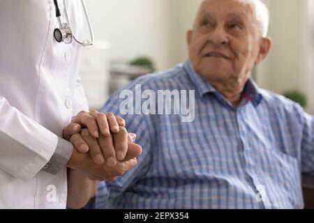 Aide-soignant en gros tenant la main d'homme mature, aide psychologique Banque D'Images