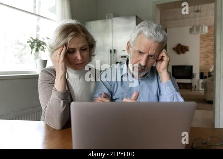 Un couple senior contrarié reçoit des mauvaises nouvelles choquantes Banque D'Images