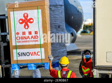 Manille, Philippines. 28 février 2021. Les membres du personnel déchargent les vaccins donnés par la Chine dans une base de la Force aérienne des Philippines à Manille, aux Philippines, le 28 février 2021. Un lot de vaccin Sinovac CoronaVac offert par la Chine est arrivé dimanche aux Philippines, le premier vaccin COVID-19 à atteindre le pays de l'Asie du Sud-est. La livraison des vaccins permet aux Philippines de commencer bientôt la vaccination de masse, marquant une nouvelle phase dans la lutte du pays contre le COVID-19 qui a infecté 576,352 et tué 12,318. Crédit: Rouelle Umali/Xinhua/Alamy Live News Banque D'Images