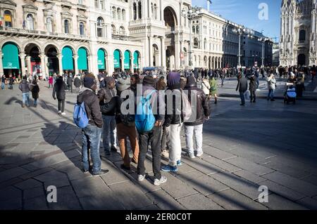 Milan, Italie - 11 janvier 2019: Hommes noirs africains, hommes, immigrants debout sur la place du Dôme de Milan, avec des touristes Banque D'Images