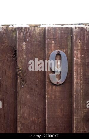 Maison numéro 9 sur une clôture en bois rugueux Banque D'Images