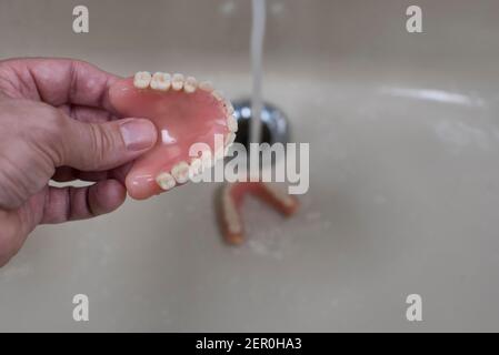Nettoyage des prothèses dans l'évier avec de l'eau courante Banque D'Images