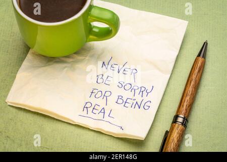 Ne soyez jamais désolé d'être une véritable écriture inspirante sur une serviette avec une tasse de café, concept de développement personnel Banque D'Images