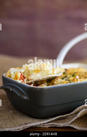 chou-fleur cuit avec filet de poulet et légumes nappés de fromage dans un moule en céramique Banque D'Images