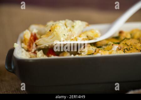 chou-fleur cuit avec filet de poulet et légumes nappés de fromage dans un moule en céramique Banque D'Images