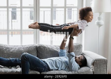 Heureux Noir père et petit fils faisant des exercices drôles Banque D'Images