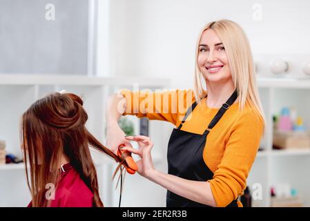 Le coiffeur serpente à l'aide d'un fer à repasser Banque D'Images