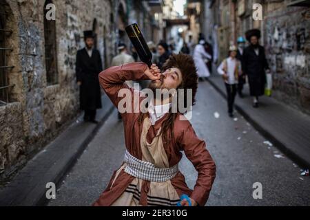 Jérusalem, Israël. 28 février 2021. Un juif ultra-orthodoxe habillé en costume, prend part aux célébrations de la fête juive de Purim dans le quartier Mea She'arim de Jérusalem. Purim, également appelé le Festival des lots, est une fête juive de type carnaval qui commémore la sauvegarde du peuple juif d'un complot pour massacrer tous les Juifs dans l'ancien empire persan, tel que raconté dans le Livre d'Esther. Crédit : Ilia Yefimovich/dpa/Alay Live News Banque D'Images