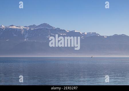 Un bateau sur le lac brumeux, le lac Léman et les Alpes vus de Lausanne, Suisse Banque D'Images