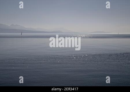 Un bateau sur le lac brumeux, le lac Léman et les Alpes vus de Lausanne, Suisse Banque D'Images