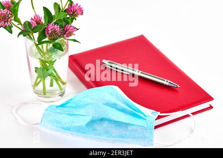 masque de protection du visage avec agenda sur fond blanc. stratégie de récupération de rabotage après l'attaque du coronavirus concept Banque D'Images