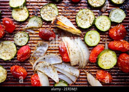 Feuille alimentaire poêle légumes rôtis courgettes oignons tomates cerises Banque D'Images