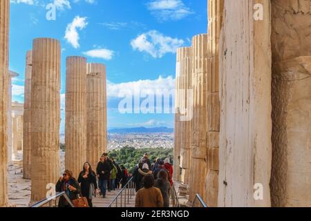 1-12-2018 Athènes, Grèce- touristes sortant et entrant dans le complexe Parthénon sur l'Acropole d'Athènes en hiver avec Athènes et les montagnes dans le Th Banque D'Images