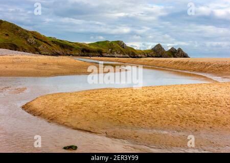 Pennard Pill un ruisseau qui coule au-dessus de la plage de sable À Three Cliffs Bay, sur la côte sud du Gower Peninsula près de Swansea dans le sud du pays de Galles, Royaume-Uni Banque D'Images