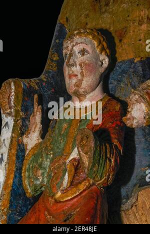 Le Christ Child aux yeux bleus et aux cheveux dorés porte des robes rouges, vertes et or alors qu’il est assis sur les genoux de sa mère dans ce détail d’une statue en bois polychrome vierge Enthroned de 1100s. Dans le réfectoire de la Monastère royale de Brou, fondée début 1500s à Bourg-en-Bresse, Ain, Auvergne-Rhône-Alpes, France, pour abriter les tombes royales de la Maison de Savoie. L'œuvre a subi des dommages importants, la Vierge manquant maintenant ses deux mains et le bras gauche du bébé Jésus se terminant dans une souche, mais la peinture originale est encore brillante après plus de huit siècles. Banque D'Images