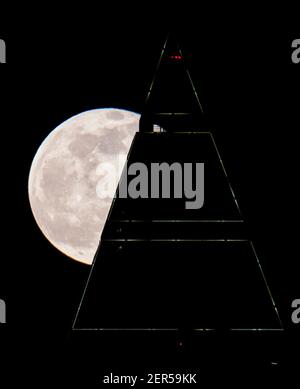 28 février 2021, Hessen, Francfort-sur-le-main : la pleine lune est au-dessus du sommet du Messeturm à Francfort. Les températures redescendent en dessous du point de congélation, surtout la nuit. Photo : Boris Roessler/dpa Banque D'Images