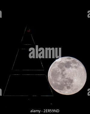 28 février 2021, Hessen, Francfort-sur-le-main : la pleine lune est au-dessus du sommet du Messeturm à Francfort. Les températures redescendent en dessous du point de congélation, surtout la nuit. Photo : Boris Roessler/dpa Banque D'Images