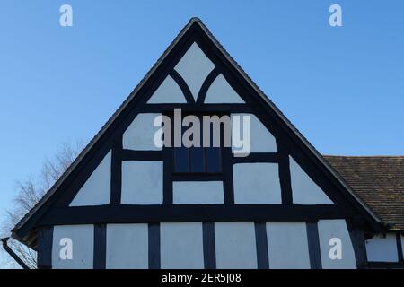 Maison médiévale en bois noir et blanc, toit avec fenêtre, ancien bâtiment traditionnel anglais du Moyen-âge Banque D'Images