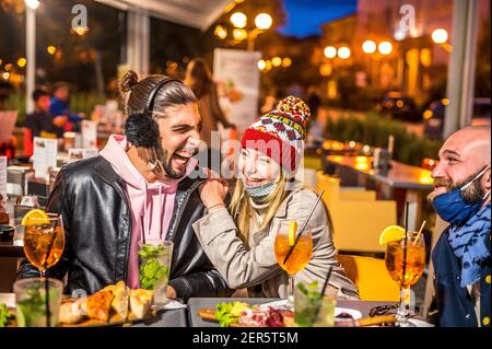 Couple prenant un cocktail au bar la nuit en portant le visage Masque - Nouveau concept de style de vie normal avec des amis heureux faire du toasting d Banque D'Images