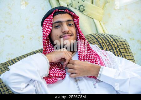 Homme musulman assis sur le canapé se sentant heureux Banque D'Images