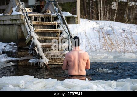 Homme debout à avanto ou dans un trou de baignade après l'hiver, dans le quartier de Munkkiniemi à Helsinki, en Finlande Banque D'Images