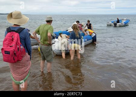 Touristes se chargeant dans un panga à la plage d'Espumilla, île de Santiago, îles Galapagos, Equateur Banque D'Images