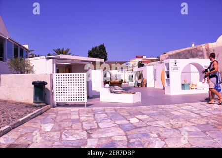 Santorini, Grèce - 11 septembre 2017 : marché de souvenirs typique dans la rue commerciale de l'île grecque appelée Santorini et touristes avec passe familial Banque D'Images