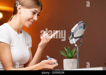 Femme souriante avec lentilles pour les yeux de contact et contenant à la main. Banque D'Images