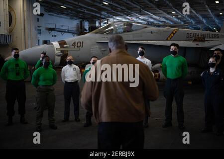 Le secrétaire américain à la Défense, Lloyd J. Austin III, au centre, s'entretient avec les membres du service lors d'une visite au porte-avions de la classe Nimitz USS Nimitz à homeport, à la base navale de San Diego le 25 février 2021 à San Diego, en Californie. Banque D'Images