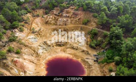 Vue aérienne de la fosse minière d'opencast abandonnée à Mathiatis, Chypre. Le lac rouge acide est le résultat de l'extraction du minerai de pyrite Banque D'Images