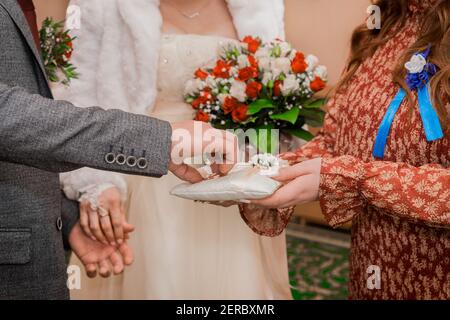 Les mains du témoin au mariage donnent des anneaux de mariage de marié. Échange d'anneaux de mariage. Banque D'Images