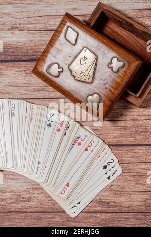 Boîte en bois pour cartes de poker et cartes sur une table en bois. Banque D'Images