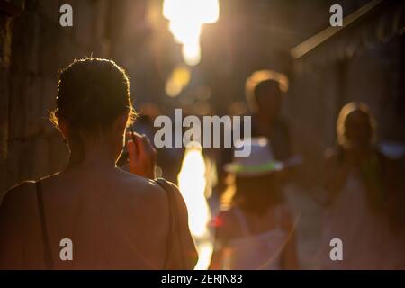 Touristes marchant dans les rues de la vieille ville de Dubrovnik au coucher du soleil. Banque D'Images
